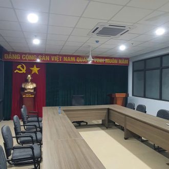 Phông hội trường với rèm cuốn cửa sổ hai bên sân khấu và bàn chủ tọa
