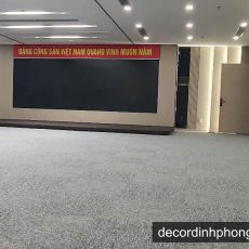 Thảm cuốn màu xám trải sàn hội trường với banner Đảng Cộng sản Việt Nam