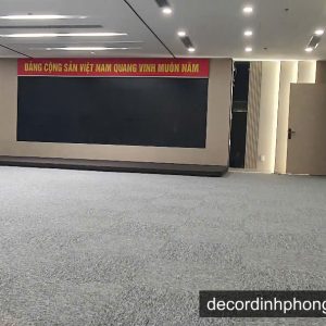Thảm cuốn màu xám trải sàn hội trường với banner Đảng Cộng sản Việt Nam
