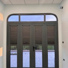 Rèm tổ ong màu nâu lắp cửa vòm cổng chính nhà phố