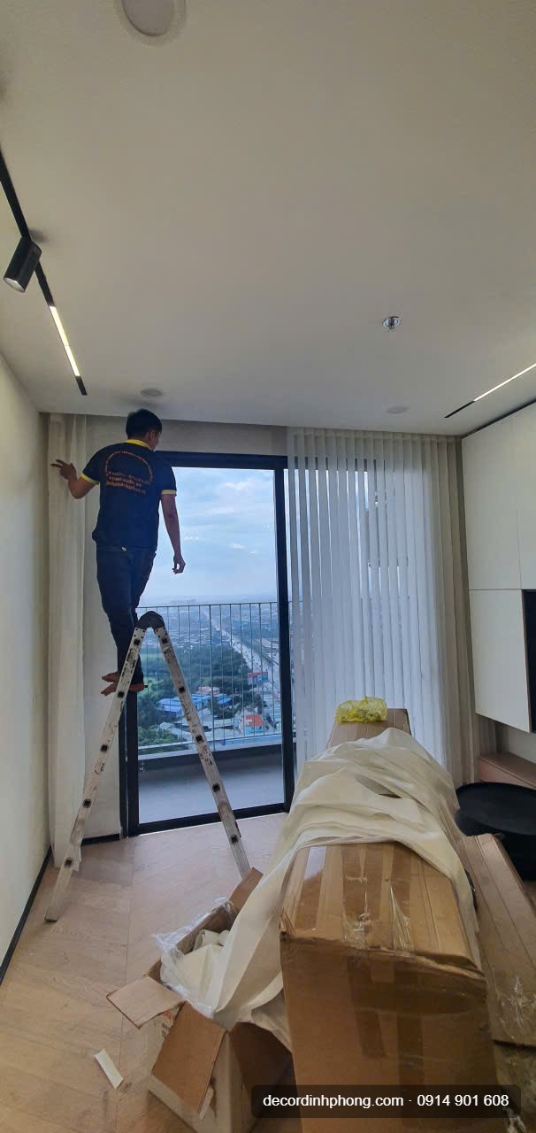 Nhân viên Đỉnh Phong tháo rèm cửa trên thang trước khi vệ sinh