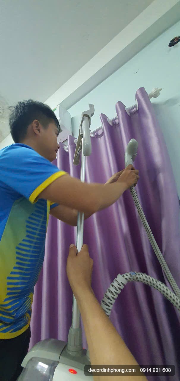 Nhân viên Đỉnh Phong dùng máy vệ sinh hơi nước xịt rèm cửa tại chỗ