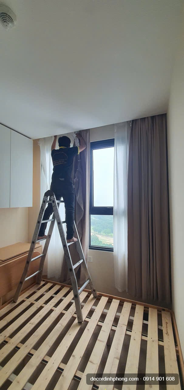 Nhân viên Đỉnh Phong lắp lại rèm cửa lên thanh treo